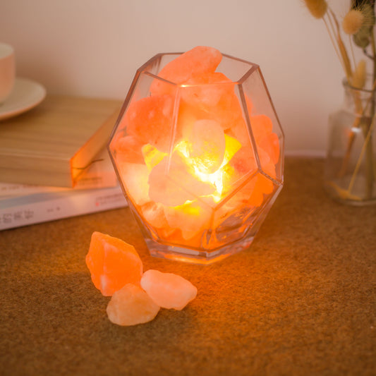 Saltlampa i geometrisk glasskål med saltkristaller