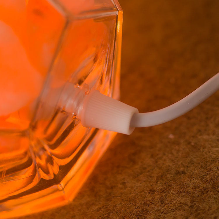 Saltlampa i geometrisk glasskål med saltkristaller
